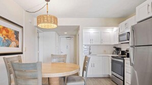 A modern kitchen with white cabinets, stainless steel appliances, a round wooden table with chairs, and a hanging light fixture. - SPECIAL OFFER Pay for 5 nights get 7 nights
Caloosa Cove Resort  Islamorada Key (Islamorada)