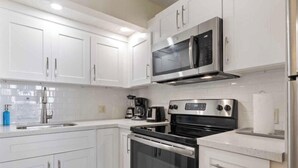 A modern kitchen with white cabinets, stainless steel appliances, a built-in oven, and a coffee maker. - SPECIAL OFFER Pay for 5 nights get 7 nights
Caloosa Cove Resort  Islamorada Key (Islamorada)