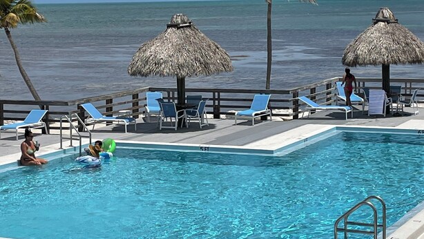 A pool area with lounge chairs, a pool, and a view of the ocean. - SPECIAL OFFER Pay for 5 nights get 7 nights
Caloosa Cove Resort  Islamorada Key (Islamorada)
