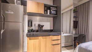 Eine kleine Küchenzeile mit Kühlschrank, Mikrowelle und Kaffeemaschine.