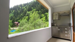 A small kitchen with a window overlooking a forested area. - soylu otel restoran (Caykara)