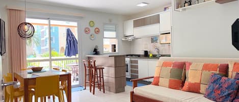 A compact living space with a dining area, kitchenette, and a sofa.