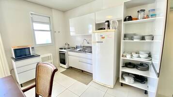 Una cocina funcional equipada con microondas, estufa, fregadero y refrigerador.
