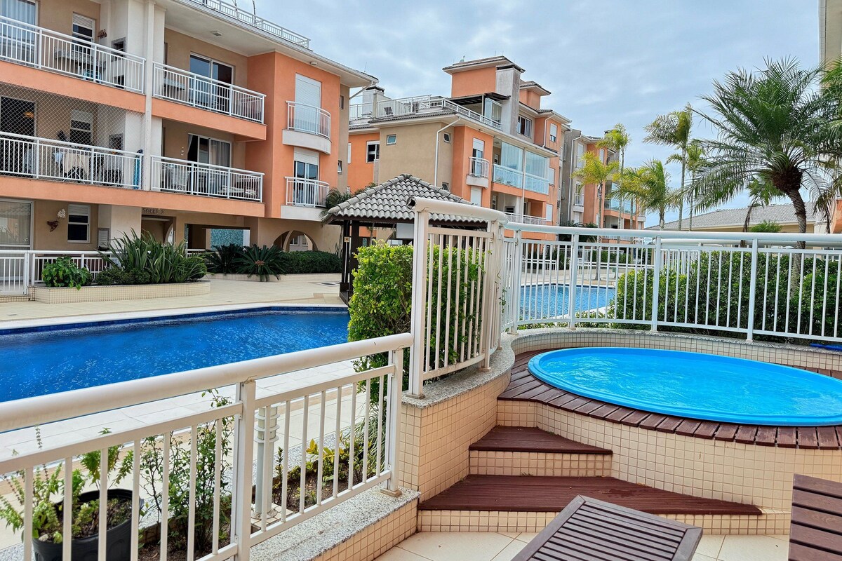 A residential building with balconies, a swimming pool, and a small gazebo.