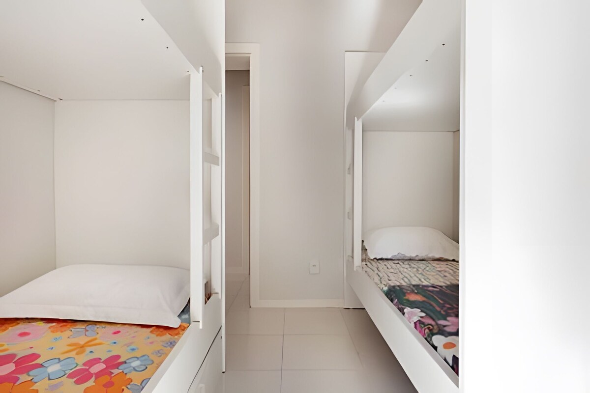 A room with two bunk beds, a door, and a tiled floor.