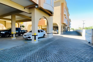 A parking garage with multiple levels and a covered walkway. - Residencial com piscina (Florianópolis)