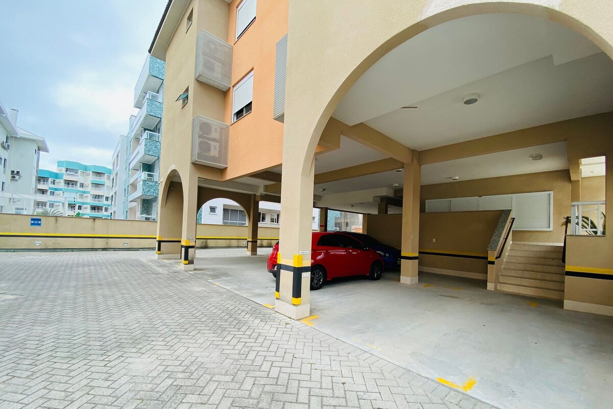 A multi-level parking garage with a red car parked under an archway.