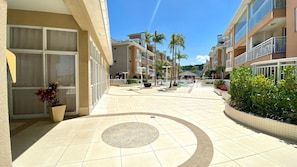 Un patio de hotel con piscina, palmeras y un pabellón.