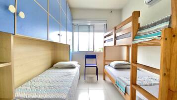 Un dormitorio con literas, una silla y una ventana.