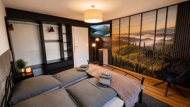 Un dormitorio moderno con una cama grande, un armario, un escritorio y una silla.