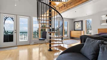 Un intérieur moderne avec un escalier en colimaçon, un balcon offrant une vue agréable et un coin salon confortable.