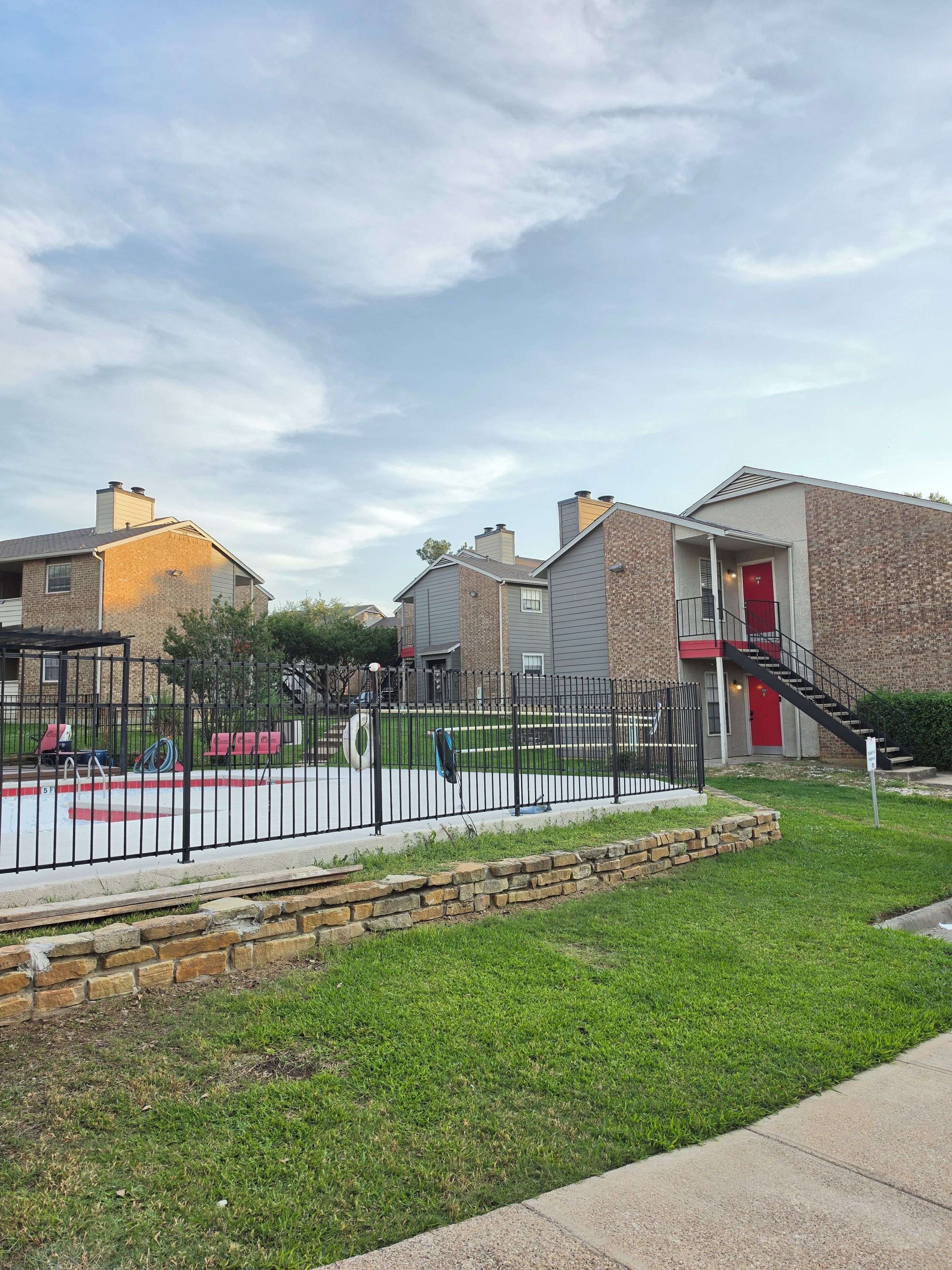 A residential area with houses, a swimming pool, and a fenced yard.