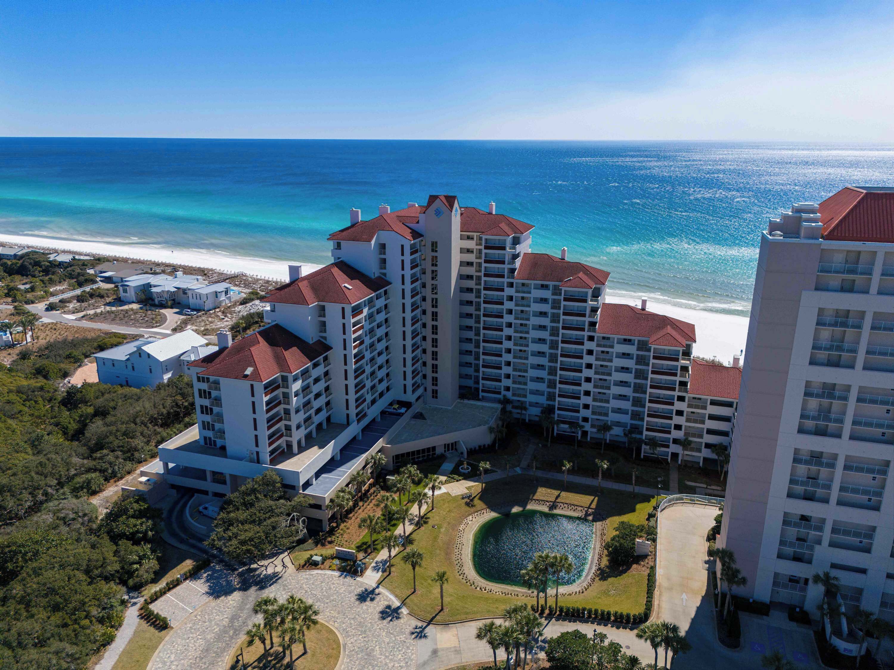 Un hôtel de grande hauteur doté de nombreux balcons, d’une cour intérieure et offrant une vue sur la plage.