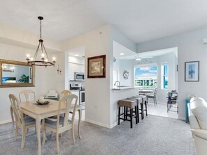 Una cocina moderna con comedor, barra y sala de estar con vistas.