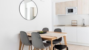 Una cucina moderna con mobili bianchi, un forno a microonde e un lavandino.