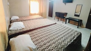 A hotel room with two beds, a desk, a chair, a television, and a mirror.