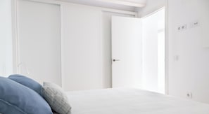 Ein Schlafzimmer mit einem Bett, einem Kleiderschrank und einer Tür.