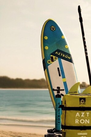 A surfboard with the brand 'AZTRON' and a yellow life jacket with the same brand name. - Apartamento Villalobos 2 by Cádiz Time Apartments (Ciudad de Cádiz)