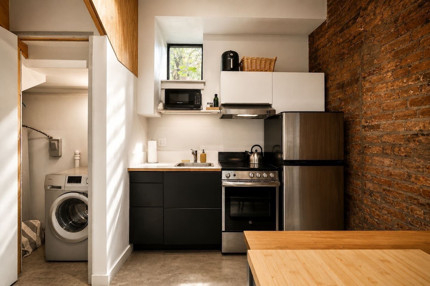 Une cuisine compacte équipée d’un lave-linge, d’un four à micro-ondes, d’une cuisinière et d’un réfrigérateur.