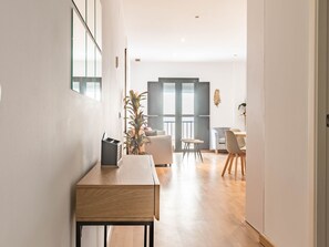 Ein modernes Interieur mit einem Holztisch, einem Topfpflanzen und einem Essbereich mit Stühlen und einem Tisch.