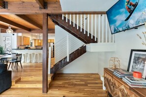 Ein modernes Interieur mit einer Holztreppe, einem Essbereich und einer Küche.