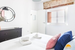 Ein modernes Schlafzimmer mit Bett, Schminktisch und Spiegel.