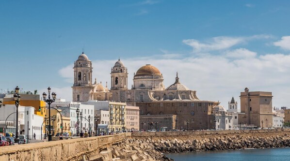 A coastal cityscape with historic architecture, including domed buildings and a prominent tower. - Casa Rehala YOR by Cadiz Time (Cádiz)