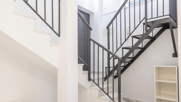 A modern staircase with black railings and white walls. - Loft Santa Maria by Cadiz Time (Ciudad de Cádiz)