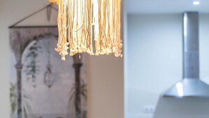 Une cuisine moderne dotée d’une hotte de cuisson en acier inoxydable et d’un mur décoratif agrémenté d’une plante.