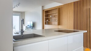 Uma cozinha moderna com pia embutida, prateleiras de madeira e uma janela grande.