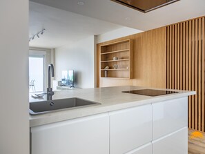 Eine moderne Küche mit integriertem Spülbecken, einer Holzeinheit und einem großen Fenster.