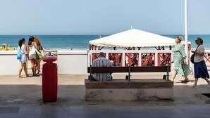 A beachside walkway with a white canopy structure, a bench, and a trash bin. - Delfin Azul 2 FREE PARKING by Cadiz Time (Cádiz)