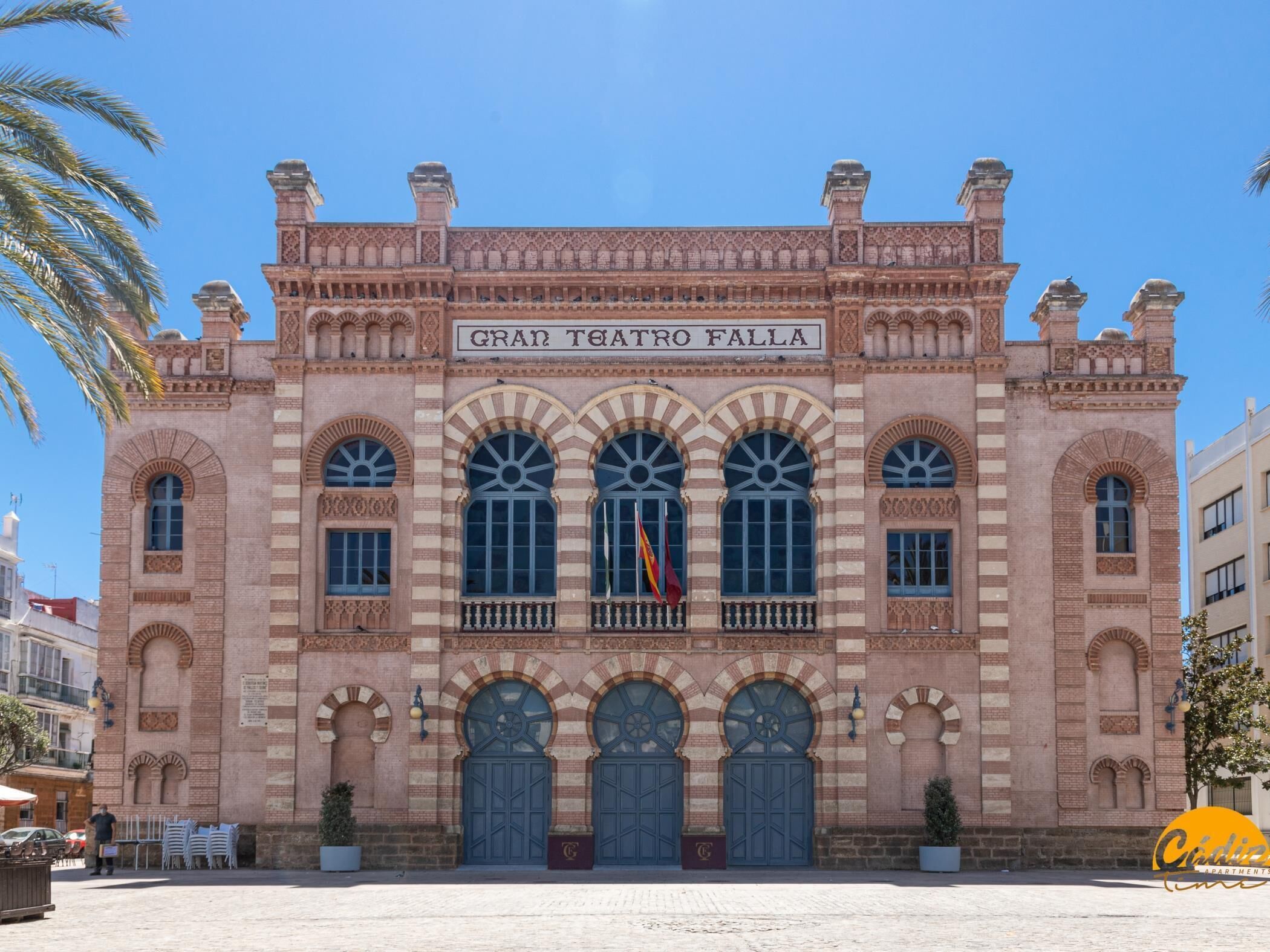 A historic building with the name 'GRAN TEATRO FALLA' on the facade, featuring arched windows and decorative brickwork.