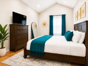 A bedroom with a bed, a dresser, a television, a surfboard, and a window with curtains. - 2 Apts, 2bd 2ba, Sleeps 10, Clean & Reliable, Near NYC (Scotch Plains)
