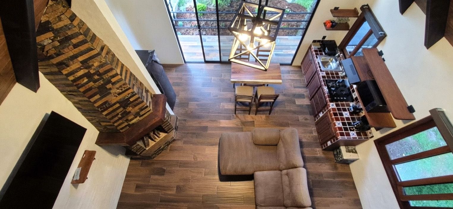 A spacious living area with a wooden floor, a sofa, a dining table, and a kitchen area with a built-in oven.