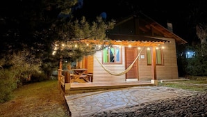 A wooden cabin with a porch, a hammock, and string lights. - Paseo del Llano Cabañas & Suites (Mazamitla)