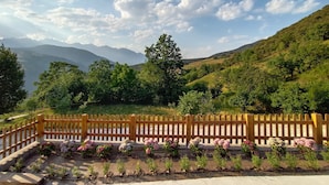 A scenic view of a mountainous landscape with a wooden fence and flower beds. - Apartment with views to the Picos de Europa 4 pax - 1 (Tollo)