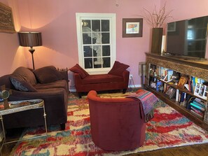 Ein Wohnzimmer mit einer Couch, einem Sessel und einem Bücherregal.
