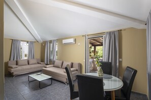 Ein Wohnzimmer mit einer Couch, einem Couchtisch und einem Esstisch mit Stühlen.
