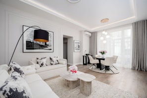 En moderne stue med sofa, sofabord, spisebord og stole.