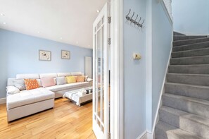 A modern living room with a sofa, coffee table, and artwork on the wall. - Whole 3-Bedroom Townhouse with Private Garden · Sleeps 7 · 2 Bathrooms (London)