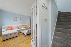 A living room with a sofa, a coffee table, and a staircase.