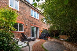 A brick house with a patio, a covered barbecue area, and a garden with bamboo. - Whole 3-Bedroom Townhouse with Private Garden · Sleeps 7 · 2 Bathrooms (London)