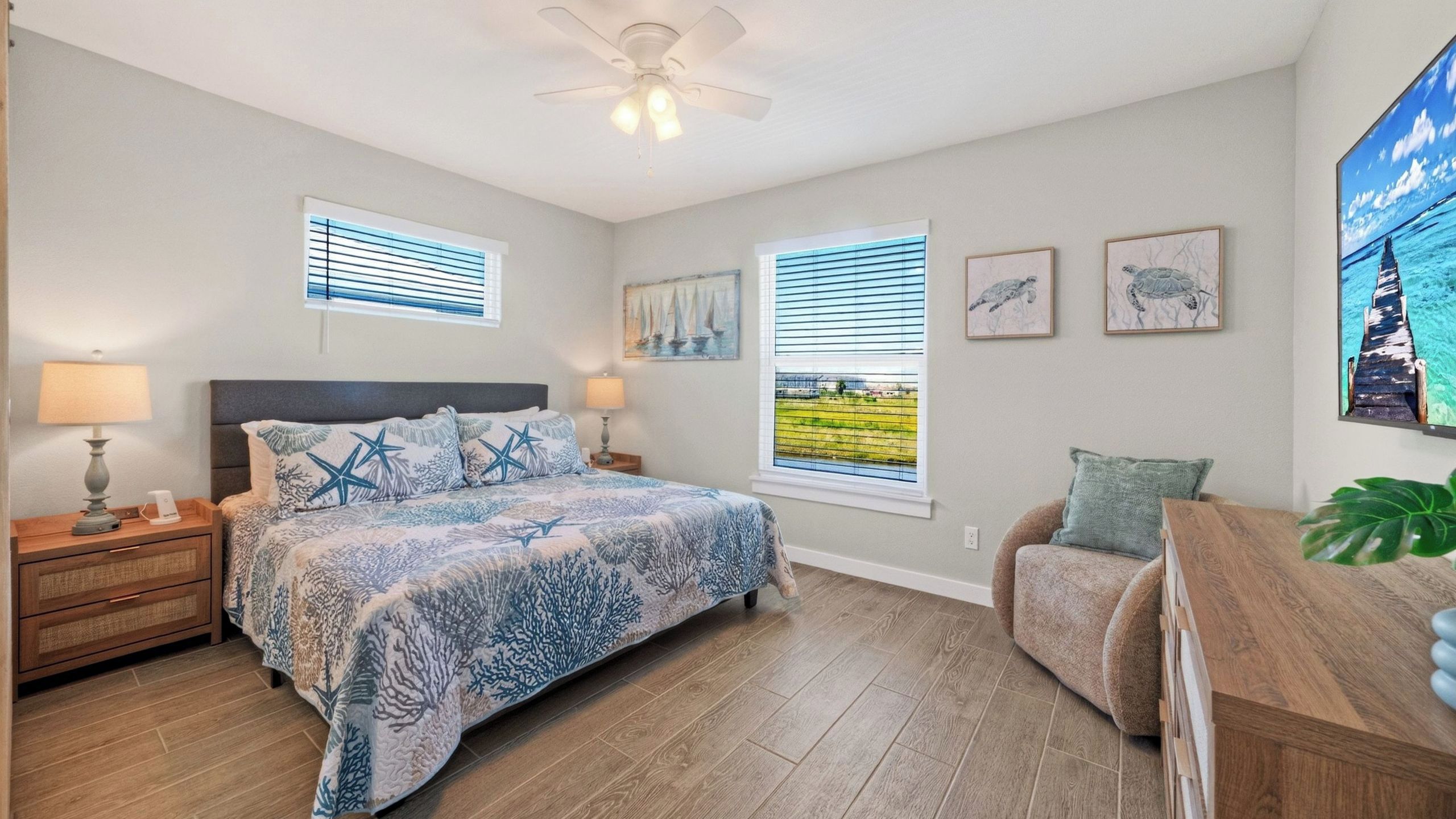 A bedroom with a bed, nightstands, a desk, and a ceiling fan.