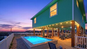 Ein zweigeschossiges Haus mit Pool, Außenbereich und Lichterkette.