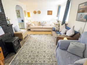 A cozy living room with a sofa, a patterned rug, and a fireplace. - Four Seasons (Grimsby)