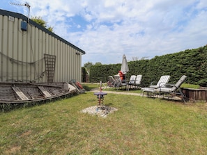 A backyard with a wooden boat, chairs, and a table. - Four Seasons (Grimsby)