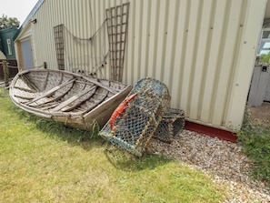 Um barco e armadilhas de lagosta ao fundo de um edifício.