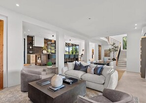 Ein geräumiger Wohnbereich mit einem modernen Sofa, einem Couchtisch und einem Kamin.