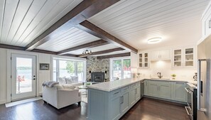 Une cuisine moderne agrémentée d’éléments en pierre, une cheminée et une vue sur l’extérieur.
